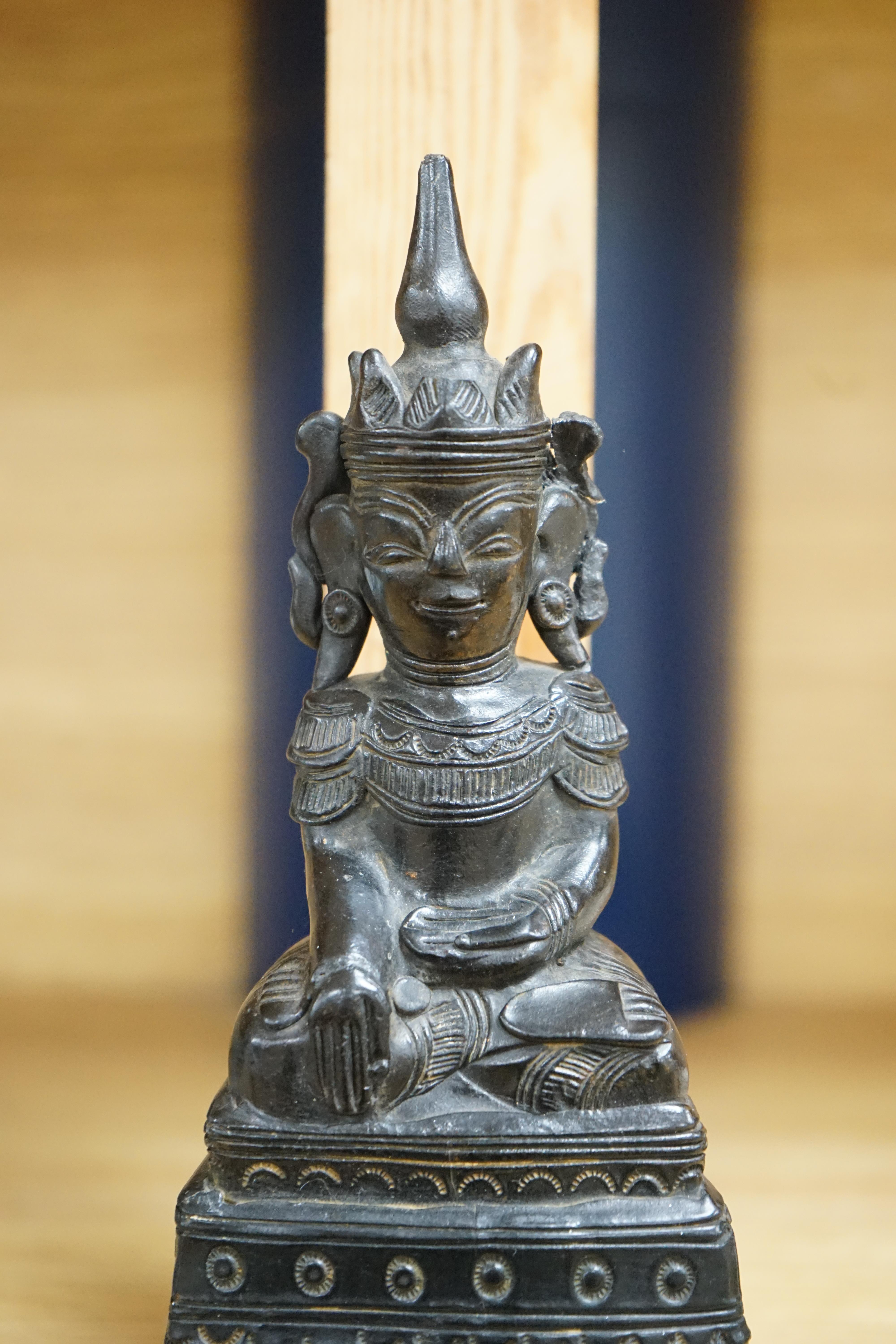 A 19th century Burmese black lacquer and wood seated figure of Buddha, 21cm high. Condition - fair, losses to the lacquer on the reverse